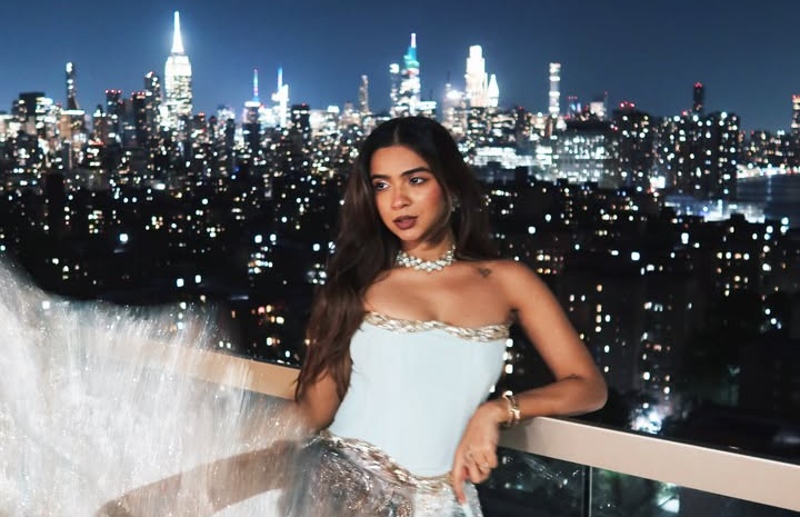 212 Apoorva Mukhija in a pale blue strapless corset gown and jewelled choker on a balcony overlooking a city skyline at night
